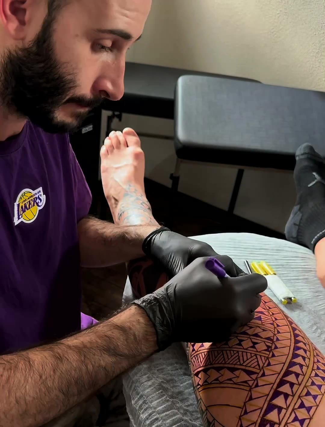Caio desenhando a arte na perna do cliente